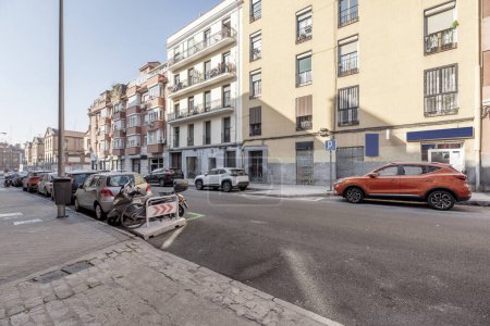 Photo for A central street in the city of Madrid with a single walking destination with cars parked on both sides on a sunny day - Royalty Free Image