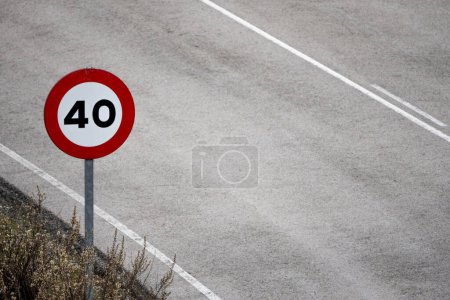 a limited speed sign on the side of a road
