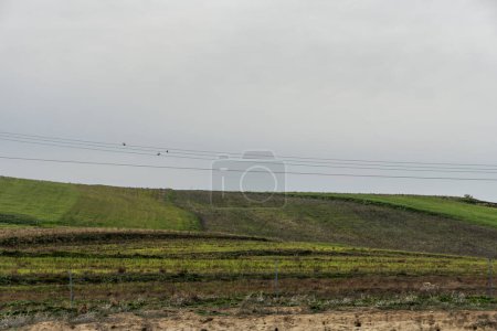 Some fallow fields with high tension lines crossing them