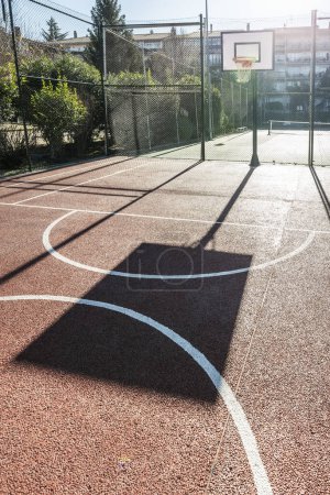 Foto de Una cancha de baloncesto al aire libre rodeada de vallas metálicas - Imagen libre de derechos
