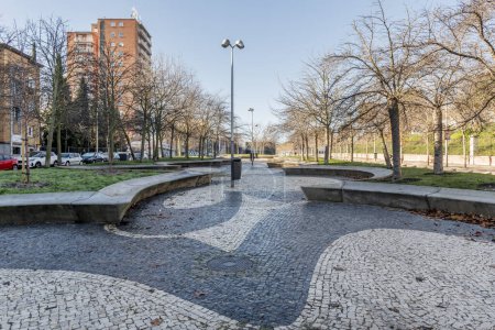 An urban promenade with two-tone Portuguese-style marble floors and gardens at the height of the stone seats