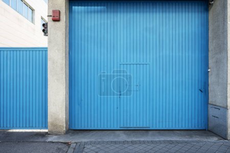 Blue metal door to access the garage area of an office building