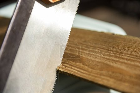 manual woodworking saw cutting a thin wooden board