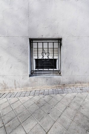 Foto de Una pequeña ventana a nivel del suelo en la calle de una casa en el sótano - Imagen libre de derechos