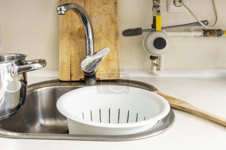 a food liquid strainer in a kitchen sink with a white countertop