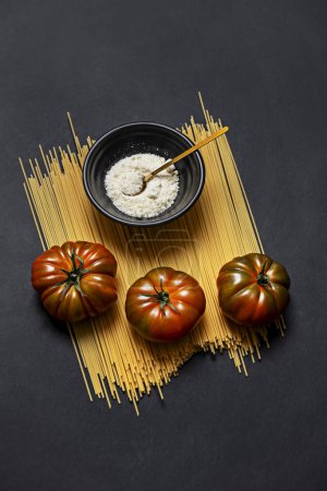 Téléchargez les photos : Quelques tomates raf lustrées sur spaghettis et fromage râpé - en image libre de droit
