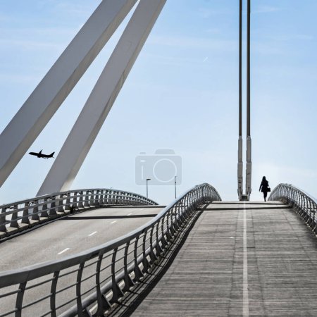 A bridge with a pedestrian walkway with a girl walking on it