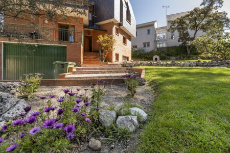 Téléchargez les photos : Jardins avec fleurs et pelouse d'une maison unifamiliale - en image libre de droit