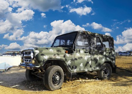 Un véhicule blindé militaire endommagé, une voiture de tourisme, une jeep et du matériel sur le champ de bataille. technique militaire