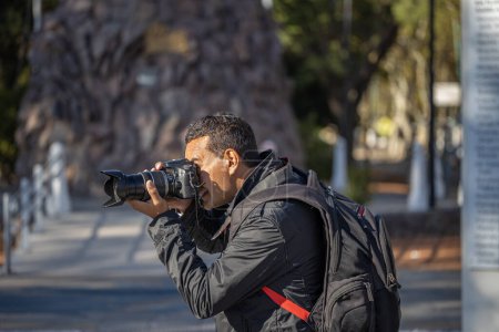 Téléchargez les photos : Photographe latino prenant une photo avec son appareil photo. - en image libre de droit