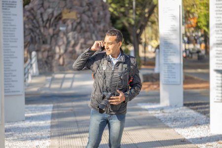 Téléchargez les photos : Jeune homme latin parlant sur téléphone portable avec espace de copie. - en image libre de droit