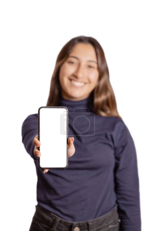 Téléchargez les photos : Fille latine hors foyer montre l'écran vide de son téléphone mobile isolé sur fond blanc. - en image libre de droit