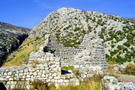 Ein alter zerstörter Turm auf dem Hügel von Gradine vor der Kulisse der Berge. Risan, Montenegro