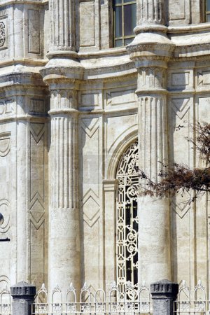 Dekor an der Fassade der Istanbuler Ortakoy-Moschee in Nahaufnahme: Steinsäulen, Gesimse, ein Fenster mit durchbrochenem Gitter im osmanischen Barockstil