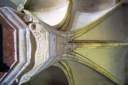 Foto de Vista de abajo hacia arriba de una antigua columna de piedra y una bóveda gótica en el Salón de los Caballeros de la Gran Corte dentro del Castillo de Corvin (Hunedoara, Rumania). - Imagen libre de derechos