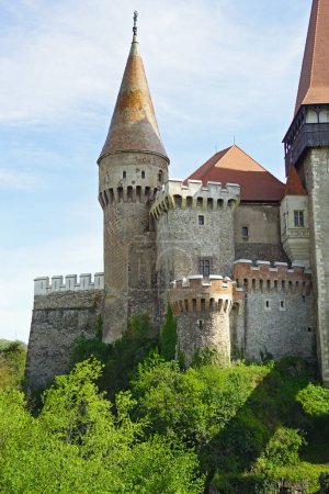 A fragment of the fairytale Hunyadi Castle in Romania: a view of the towers and bastions of the castle from the outside.   