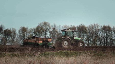 Foto de Tractors cultivates the field before seeding. Rural scene, organic farming concept - Imagen libre de derechos