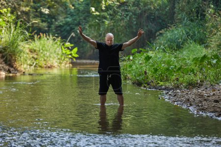 Photo for The faith of a man practicing qigong and taijiquan in the jungle river. High quality photo - Royalty Free Image