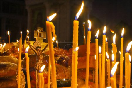 Foto de Panakhida, liturgia fúnebre en la Iglesia Ortodoxa. Los cristianos encienden velas delante de la cruz ortodoxa con un crucifijo, rezan por los muertos. El concepto de fe y religión ortodoxa. - Imagen libre de derechos