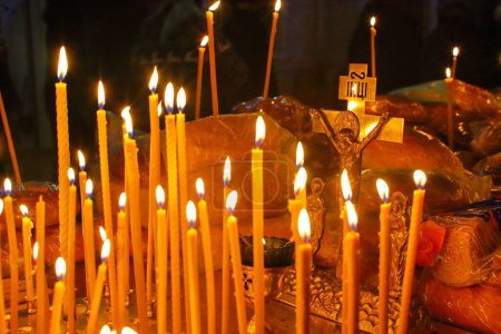 Panakhida, funeral liturgy in the Orthodox Church. Christians light candles in front of the Orthodox cross with a crucifix, pray for the dead. The concept of Orthodox faith and religion.