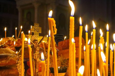 Foto de Panakhida, liturgia fúnebre en la Iglesia Ortodoxa. Los cristianos encienden velas delante de la cruz ortodoxa con un crucifijo, rezan por los muertos. El concepto de fe y religión ortodoxa. - Imagen libre de derechos