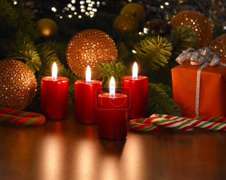 Foto de Hermosa decoración de Navidad con velas rojas ardientes e imágenes de stock caja de regalo. Adviento velas encendidas naturaleza muerta foto. Navidad velas luces fondo imágenes - Imagen libre de derechos