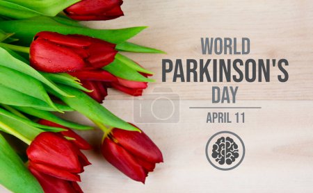 Téléchargez les photos : Affiche de la Journée mondiale de la maladie de Parkinson avec des tulipes rouges. Fleur de tulipe rouge sur une photo de fond en bois. Convient pour carte, fond, bannière. Le 11 avril chaque année. Jour important - en image libre de droit