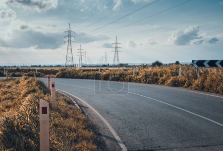 Photo for Road leading to electric towers with a moody cinematic look - Royalty Free Image