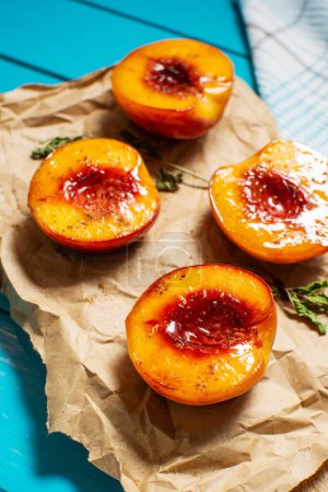 Baked peaches with honey and cinnamon on blue wooden background. summer dessert