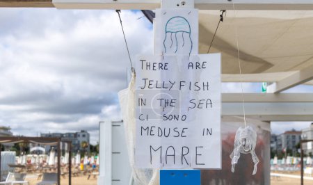 Téléchargez les photos : Un panneau sur une plage à Rimini Il y a des méduses dans la mer. - en image libre de droit