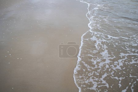Téléchargez les photos : Douce vague de la mer sur la plage de sable fin dans la journée d'été. - en image libre de droit