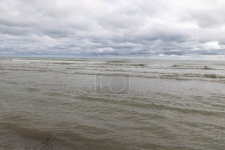 Téléchargez les photos : Le fond de la mer et le ciel bleu sur une plage de sable blanc, dans le style de gris foncé et gris, paysages marins orageux. - en image libre de droit