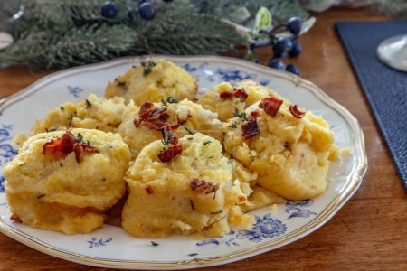 Mashed potatoes with bacon, chaddar, cheese, sour cream and chives on a holiday table at Christmas.