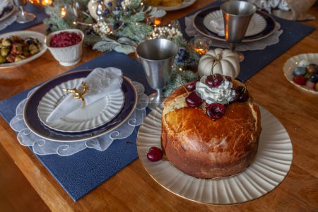 Panettone-Brot mit Kirschen und Schlagsahne auf dem Weihnachtstisch.