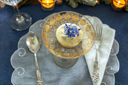 Käsekuchen-Dessert und Schlagsahne mit Goldstaub auf einer fantasievollen Kristallglasschale mit Goldätzung. 