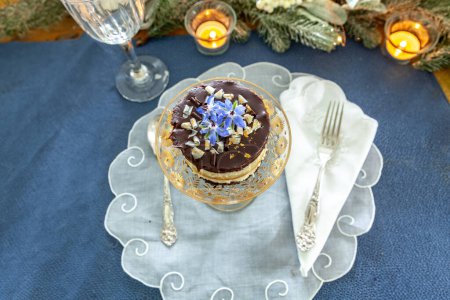 Foto de Postre de mousse de chocolate y crema batida con polvo de oro en un plato de cristal de lujo con grabado en oro. - Imagen libre de derechos
