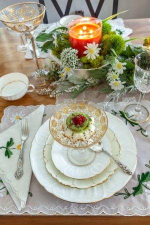 Mini tarta de queso con kiwi, frambuesa y oro comestible adornan en una compota de oro cristal en un ajuste formal de mesa de Pascua.