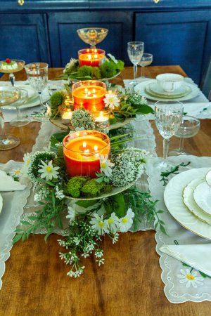 Mesa formal con margaritas, velas de melocotón y platos finos de China en Semana Santa.