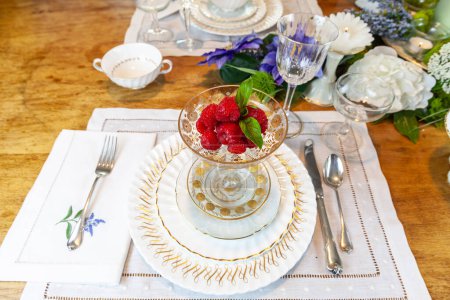 Frambuesas frescas en una compota de oro y cristal en un lugar sobre una mesa de Pascua.