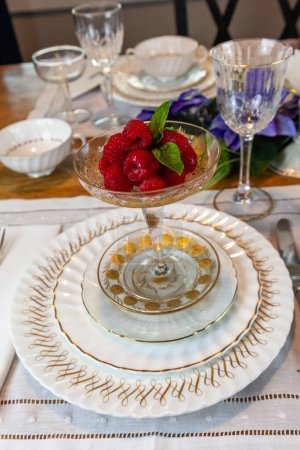 Frambuesas frescas en una compota de oro y cristal en un lugar sobre una mesa de Pascua.