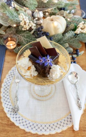 Postre de mousse de chocolate y crema batida con polvo de oro en un plato de cristal de lujo con grabado en oro. 