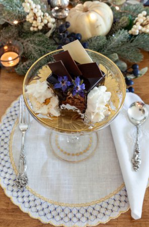 Chocolate mousse dessert and whipped cream with gold dust on a fancy crystal glass dish with gold etching.