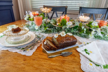 Banana bread with whipped cream served on fine China plates and crystal with gold inlay on a formal table setting.
