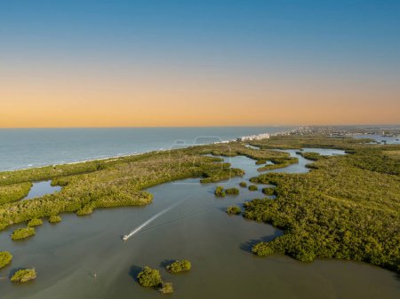 Puesta de sol sobre la vía navegable del manglar justo más allá del océano en Bonita Beach, Florida.