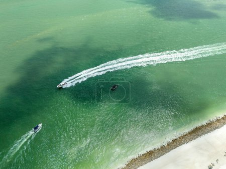 Overhead view of boats moving through the ocean water in the Gulf of Mexico in Southwest Florida.