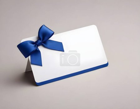 Auf einem neutralen, hellgrauen Hintergrund befindet sich eine weiße Geschenkkarte, die mit einem satinblauen Band verziert ist. Die Karte bietet viel Platz für eine personalisierte Botschaft und ist perfekt für besondere Anlässe.
