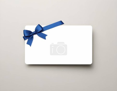 Une carte cadeau blanche ornée d'un ruban bleu satiné est centrée sur une toile de fond neutre gris clair. La carte offre amplement d'espace pour un message personnalisé et est parfaite pour les occasions spéciales.