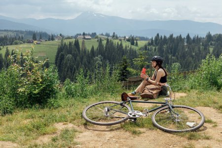 Photo for Woman cyclist ride vintage gravel bikel on nature mountains trail - Royalty Free Image