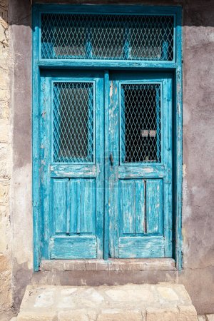 Téléchargez les photos : Accès à une maison avec une vieille porte en bois peinte à l'essence et altérée. - en image libre de droit