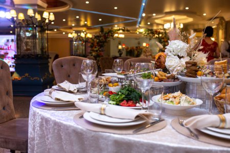 Foto de Servilletas blancas, bellamente dobladas en platos en un restaurante. Restaurante interior. - Imagen libre de derechos